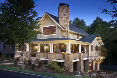 Example of a large arts and crafts brown wood exterior home design in Other