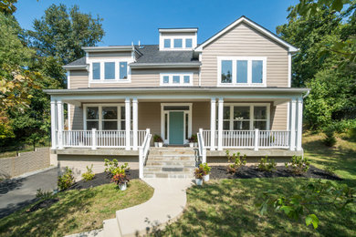 Imagen de fachada de casa beige de estilo americano grande de dos plantas con revestimiento de vinilo y tejado a dos aguas