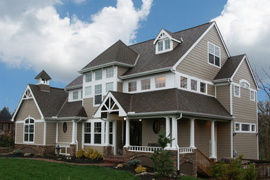 Imagen de fachada beige de estilo americano de tres plantas con revestimientos combinados