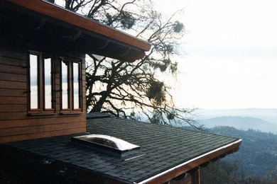 Diseño de fachada de casa marrón de estilo americano de tamaño medio de dos plantas con revestimiento de madera, tejado a la holandesa y tejado de teja de madera