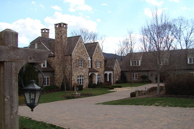 Diseño de fachada de casa gris tradicional grande de dos plantas con revestimientos combinados y tejado de teja de madera