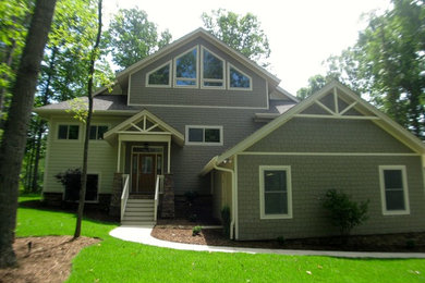 Imagen de fachada gris clásica de tamaño medio de dos plantas con revestimientos combinados y tejado a cuatro aguas