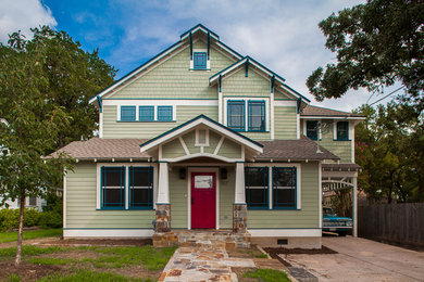 Imagen de fachada de casa verde de estilo americano de dos plantas con revestimiento de vidrio, tejado a dos aguas y tejado de teja de madera