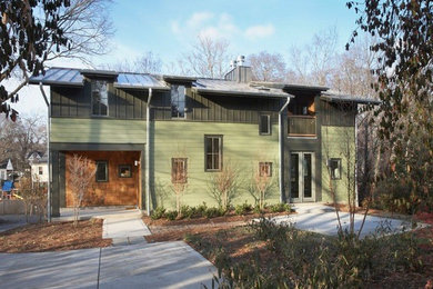 Imagen de fachada de casa multicolor contemporánea grande de dos plantas con revestimientos combinados, tejado a dos aguas y tejado de metal