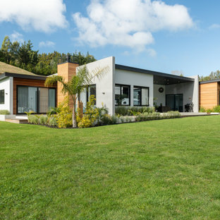 Imagen de fachada de casa multicolor, contemporánea, de tamaño medio, de una planta, con revestimiento de hormigón, tejado plano y tejado de metal