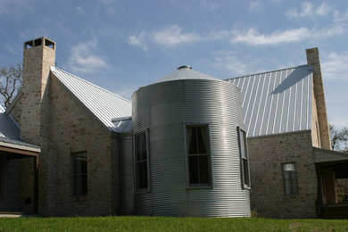 Imagen de fachada de casa multicolor campestre extra grande de dos plantas con revestimientos combinados, tejado a dos aguas y tejado de metal