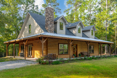 Example of a cottage brown two-story wood exterior home design in Other with a mixed material roof
