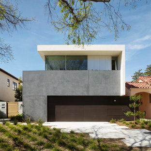 Imagen de fachada de casa beige, contemporánea, de dos plantas, con tejado plano y revestimiento de hormigón