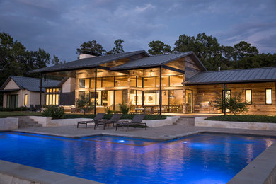 Example of a large trendy beige one-story stone exterior home design in Dallas with a metal roof