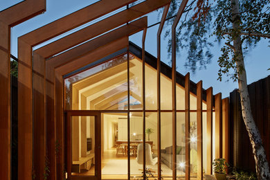 Réalisation d'une façade de maison beige design en bois de taille moyenne et de plain-pied avec un toit à deux pans.