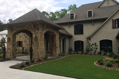 Example of a large transitional two-story stucco exterior home design in Houston