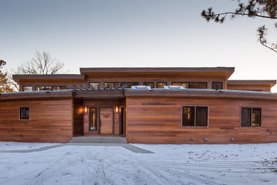 Example of a large mountain style brown one-story wood exterior home design in Minneapolis with a shed roof