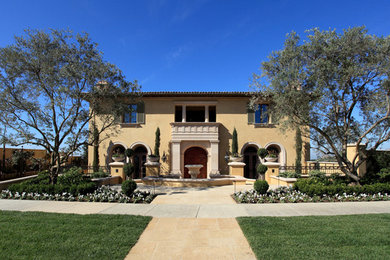 Inspiration for a large mediterranean beige two-story stucco exterior home remodel in Orange County