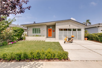 Inspiration for a large contemporary gray two-story stucco exterior home remodel in Los Angeles with a shingle roof