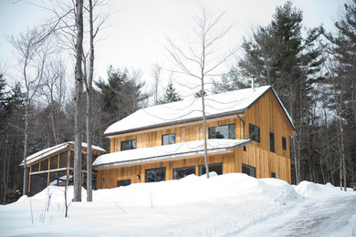Ejemplo de fachada de casa beige de estilo americano de tamaño medio de dos plantas con revestimiento de madera y tejado de teja de madera