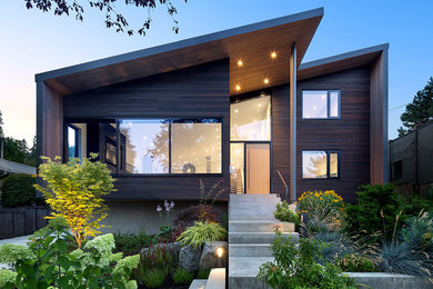 Imagen de fachada de casa marrón actual de tamaño medio de tres plantas con revestimiento de madera y tejado de un solo tendido