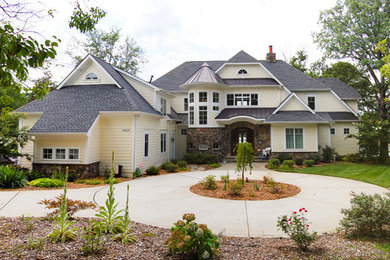 Inspiration for a large coastal yellow two-story mixed siding house exterior remodel in Charlotte with a shingle roof