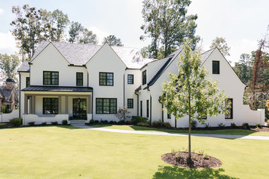 Cette photo montre une façade de maison blanche chic en brique à deux étages et plus et de taille moyenne avec un toit à deux pans et un toit mixte.