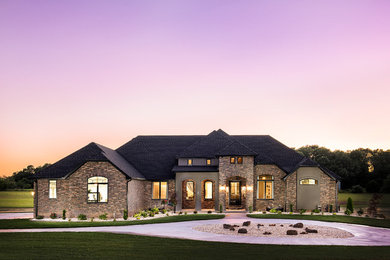 Large transitional brown two-story stone exterior home idea in Other with a shingle roof