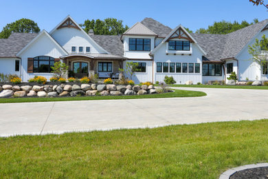 Huge farmhouse white three-story mixed siding house exterior photo in Other with a mixed material roof