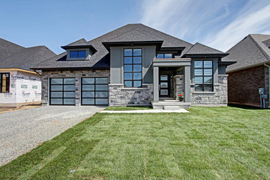 Cette photo montre une façade de maison grise chic en stuc de taille moyenne et de plain-pied avec un toit à quatre pans et un toit en shingle.