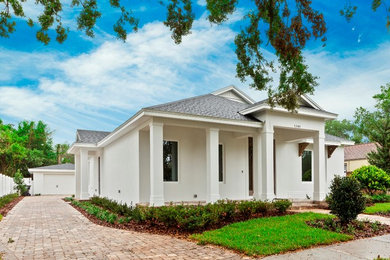 Example of a transitional white one-story stucco house exterior design in Orlando with a hip roof and a shingle roof