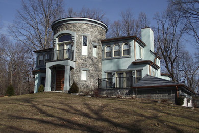 Modelo de fachada de casa azul de estilo americano grande de dos plantas con revestimientos combinados y tejado de teja de madera