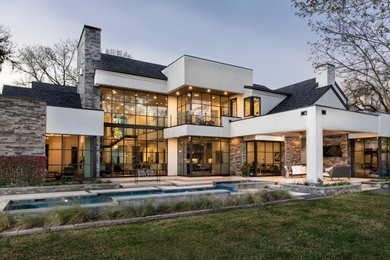 Imagen de fachada de casa blanca contemporánea de dos plantas con tejado a dos aguas y tejado de teja de madera