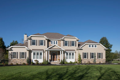 Imagen de fachada de casa beige clásica de tamaño medio de dos plantas con revestimiento de piedra y tejado de teja de madera