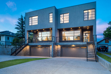 Ejemplo de fachada de casa bifamiliar gris minimalista de tres plantas con revestimiento de piedra y tejado plano
