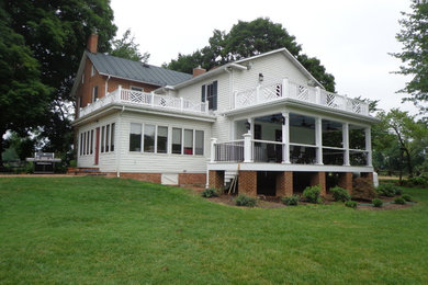 Example of a mid-sized farmhouse exterior home design in Other