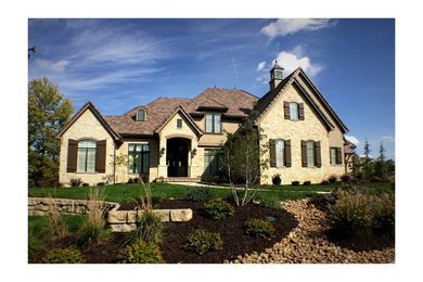 Example of a large mountain style beige three-story stucco exterior home design in Kansas City