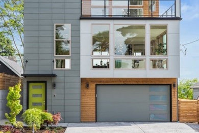 Inspiration for a mid-sized contemporary gray three-story concrete fiberboard exterior home remodel in Seattle with a mixed material roof