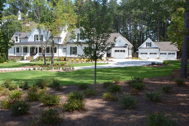 Immagine della villa grande bianca country a due piani con rivestimento in vinile, tetto a capanna e copertura a scandole