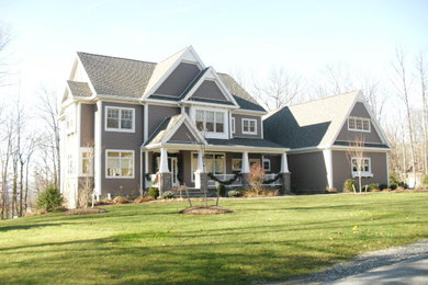 Modelo de fachada de casa gris de estilo americano grande de dos plantas con revestimiento de madera, tejado a dos aguas y tejado de teja de madera