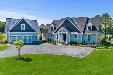 Пример оригинального дизайна: двухэтажный, деревянный, синий частный загородный дом среднего размера в стиле неоклассика (современная классика)