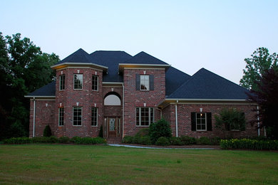 Inspiration for a large timeless red three-story brick exterior home remodel in Other