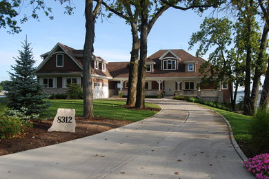 Large elegant brown two-story mixed siding house exterior photo in Chicago with a hip roof and a shingle roof
