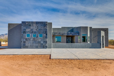 Ejemplo de fachada de casa gris minimalista de tamaño medio de una planta con revestimiento de estuco y tejado plano