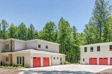 Inspiration for a huge contemporary two-story stucco house exterior remodel in Raleigh with a shingle roof