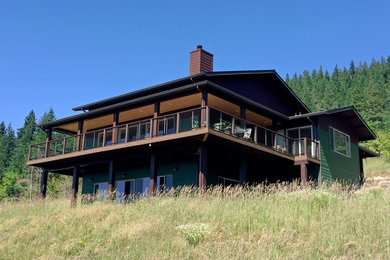 他の地域にあるトラディショナルスタイルのおしゃれな家の外観 (混合材サイディング、緑の外壁) の写真