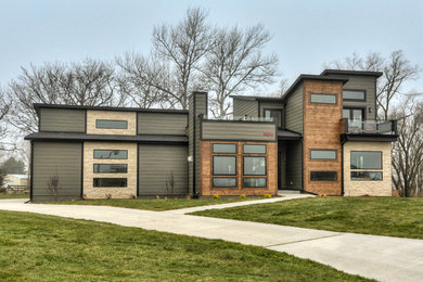 Large contemporary gray two-story concrete fiberboard exterior home idea in Other