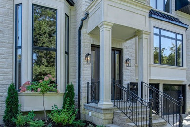 Large transitional beige two-story stone house exterior idea in Toronto with a shingle roof and a hip roof