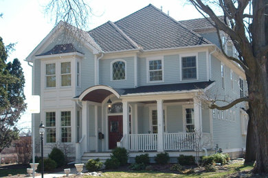 Cette photo montre une grande façade de maison bleue victorienne en bois à un étage avec un toit plat.