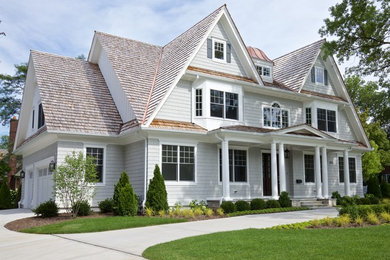 Idée de décoration pour une façade de maison grise tradition en bois de taille moyenne et à un étage avec un toit à deux pans.