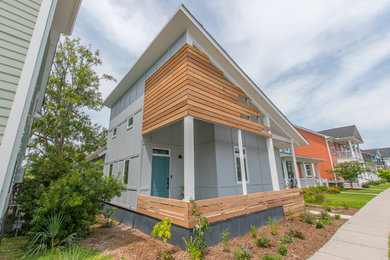 Modelo de fachada de casa gris clásica renovada de tamaño medio de dos plantas con revestimiento de aglomerado de cemento y tejado de metal