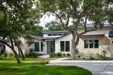 Transitional white two-story stucco house exterior photo in Austin with a metal roof