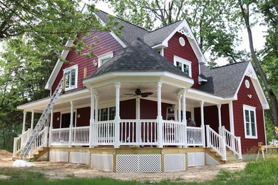 Inspiration for a large farmhouse red two-story concrete exterior home remodel in DC Metro with a gambrel roof