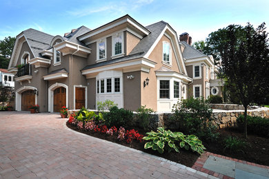 Mid-sized elegant beige two-story adobe exterior home photo in Boston with a clipped gable roof