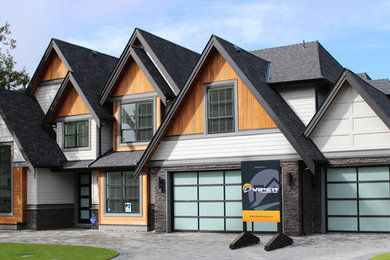 Réalisation d'une façade de maison grise design à un étage avec un revêtement mixte.